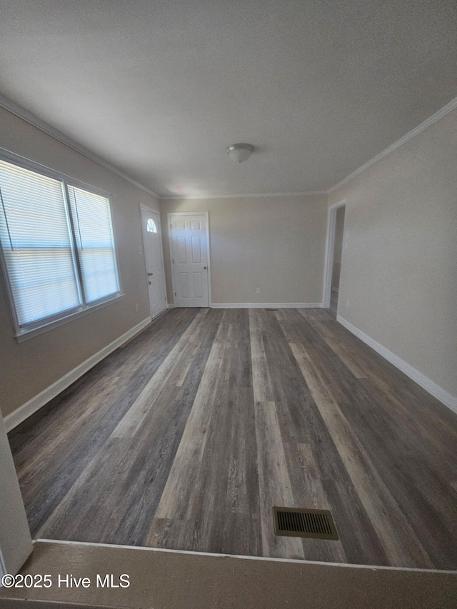 unfurnished living room with visible vents, baseboards, and crown molding