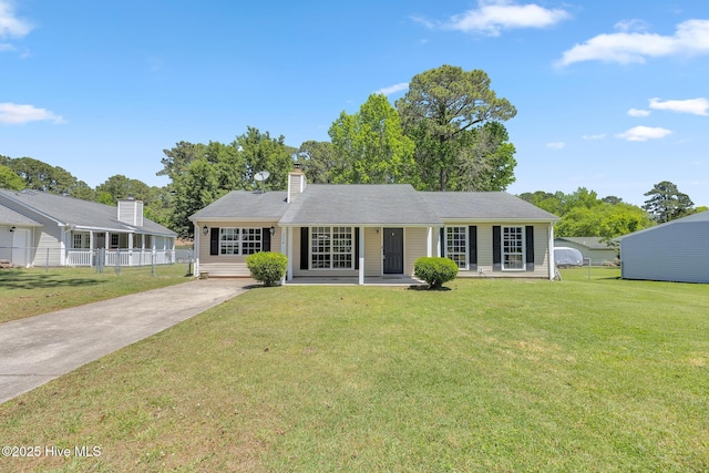 ranch-style home featuring fence, driveway, and a front yard