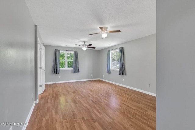 unfurnished room with baseboards, a ceiling fan, and light wood finished floors