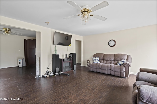 living room featuring ceiling fan, baseboards, and wood finished floors