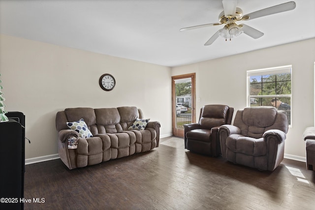 living area with baseboards, wood-type flooring, and a ceiling fan