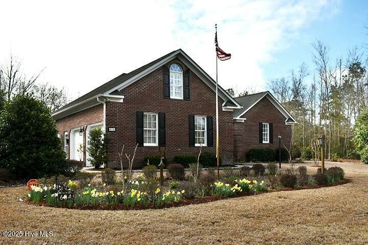 view of side of home featuring brick siding and an attached garage