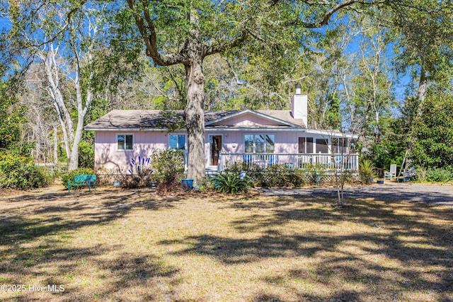 back of house with a yard, a chimney, and a sunroom