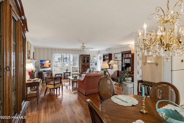 dining room featuring ceiling fan with notable chandelier, crown molding, and hardwood / wood-style floors