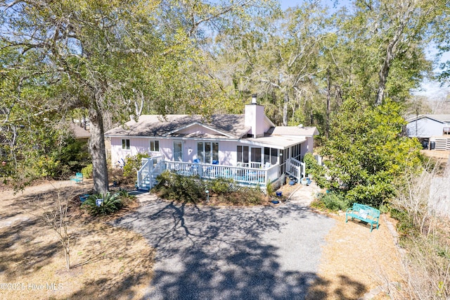 view of front of home featuring a chimney and a sunroom