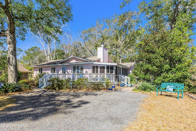 view of front of house featuring a chimney and a sunroom