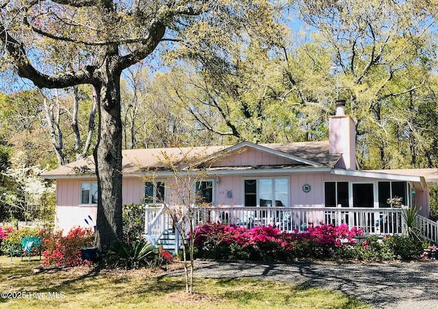 single story home with covered porch and a chimney