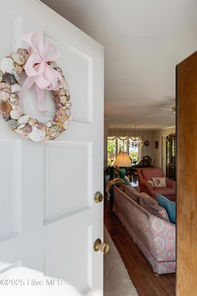 foyer entrance featuring ceiling fan with notable chandelier and wood finished floors