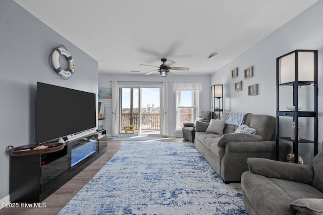 living area featuring a ceiling fan and wood finished floors