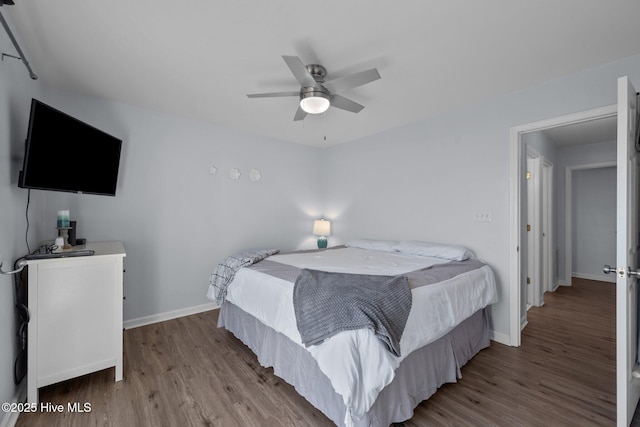 bedroom with a ceiling fan, wood finished floors, and baseboards