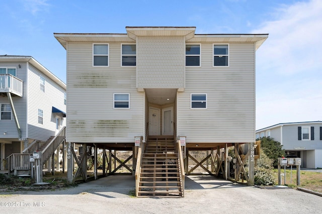 raised beach house with a carport, driveway, and stairs