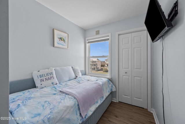 bedroom with a closet, baseboards, and wood finished floors