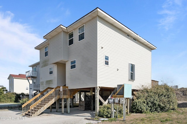 rear view of house featuring stairs and a carport