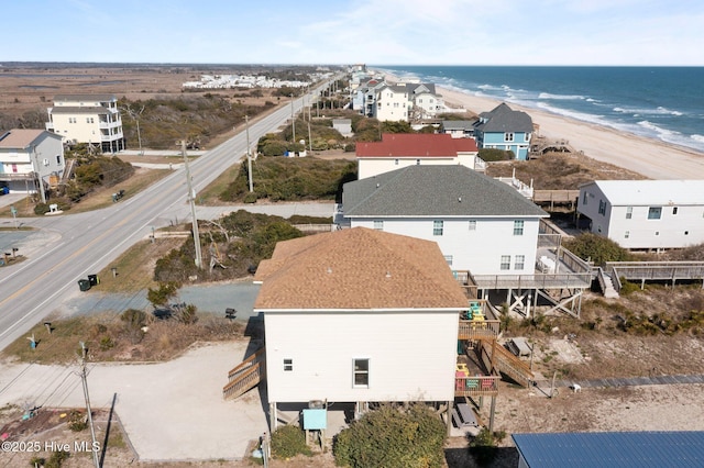 drone / aerial view featuring a residential view, a beach view, and a water view