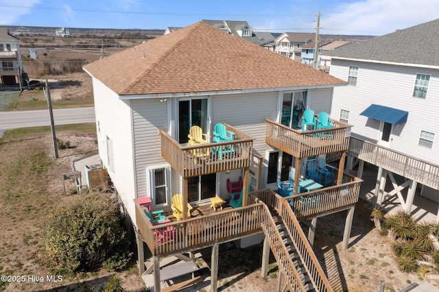 back of house featuring a balcony, a shingled roof, and a deck