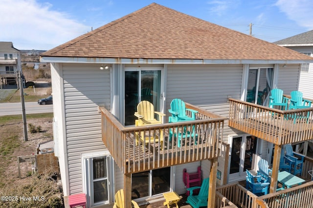 back of property featuring roof with shingles and a wooden deck