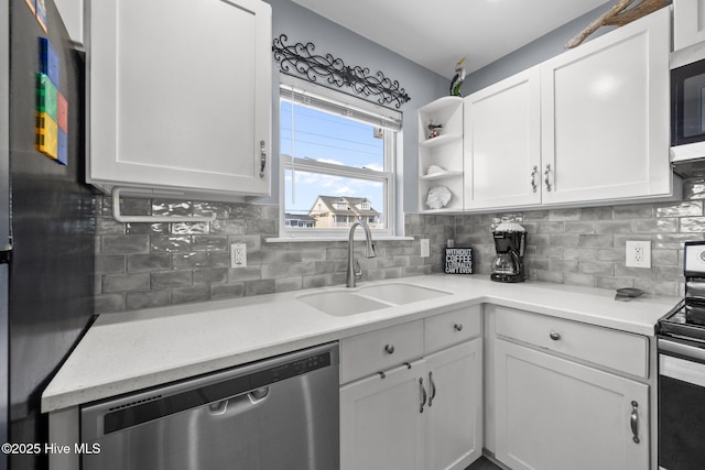 kitchen featuring a sink, backsplash, appliances with stainless steel finishes, and white cabinets