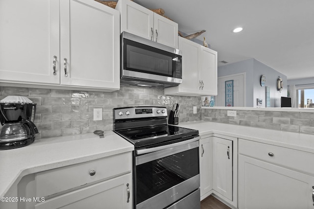 kitchen featuring tasteful backsplash, appliances with stainless steel finishes, white cabinetry, and light countertops