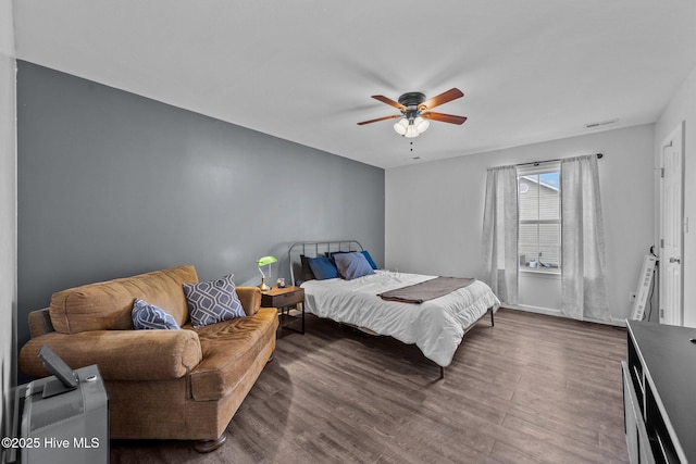 bedroom featuring visible vents, baseboards, a ceiling fan, and wood finished floors