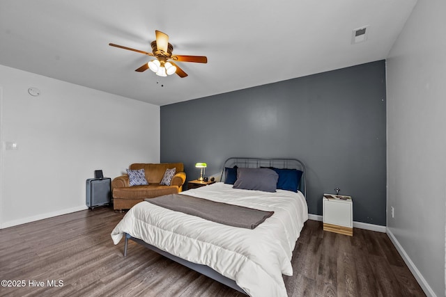 bedroom featuring ceiling fan, wood finished floors, visible vents, and baseboards