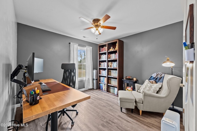 home office featuring visible vents, wood finished floors, and a ceiling fan