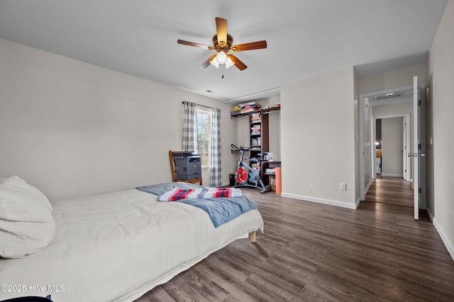 bedroom with ceiling fan, visible vents, baseboards, and wood finished floors