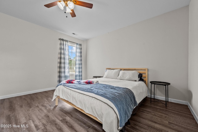 bedroom with a ceiling fan, wood finished floors, visible vents, and baseboards