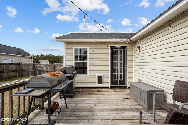 wooden terrace featuring a grill and fence