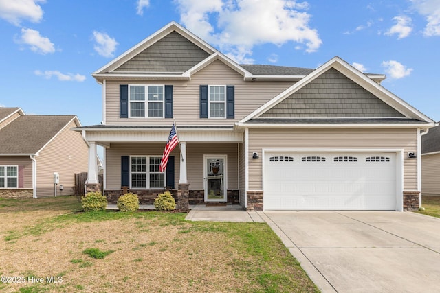 craftsman house with a front yard, covered porch, concrete driveway, a garage, and stone siding