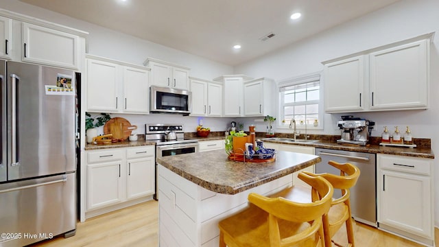 kitchen featuring visible vents, recessed lighting, white cabinets, stainless steel appliances, and a sink