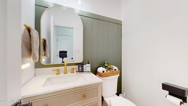 half bathroom with vanity and toilet