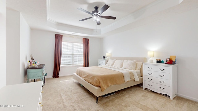 bedroom with light carpet, a raised ceiling, baseboards, and ornamental molding