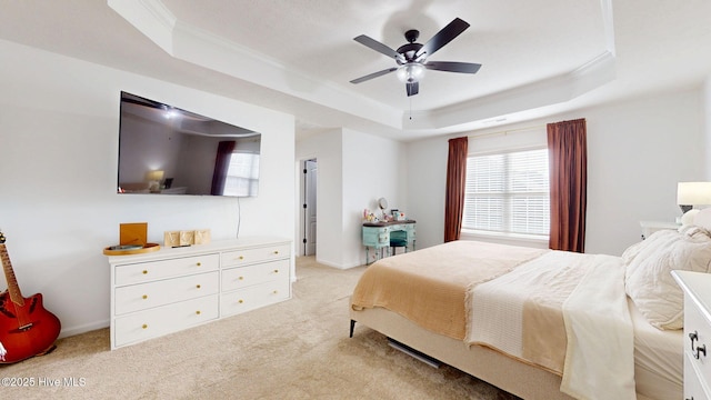 bedroom featuring a tray ceiling, light carpet, a ceiling fan, and crown molding