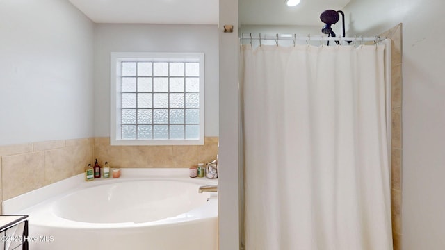 bathroom featuring curtained shower and a garden tub