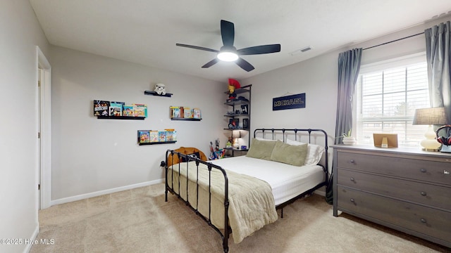 bedroom with visible vents, light colored carpet, a ceiling fan, and baseboards