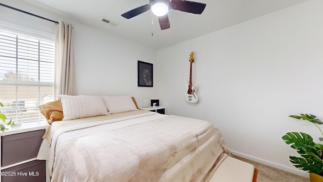 carpeted bedroom with visible vents, ceiling fan, and baseboards