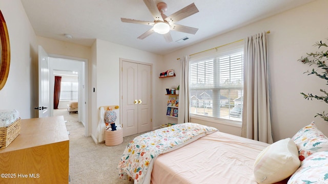 bedroom with light carpet, visible vents, multiple windows, and a closet