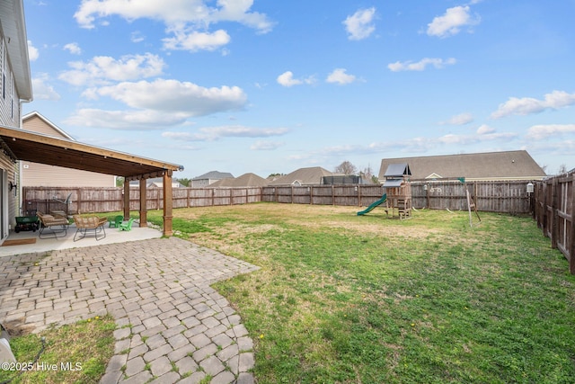 view of yard featuring a patio, a fenced backyard, and a playground