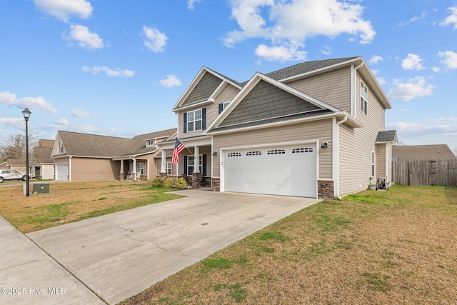 view of front of home with a front lawn, fence, concrete driveway, stone siding, and an attached garage