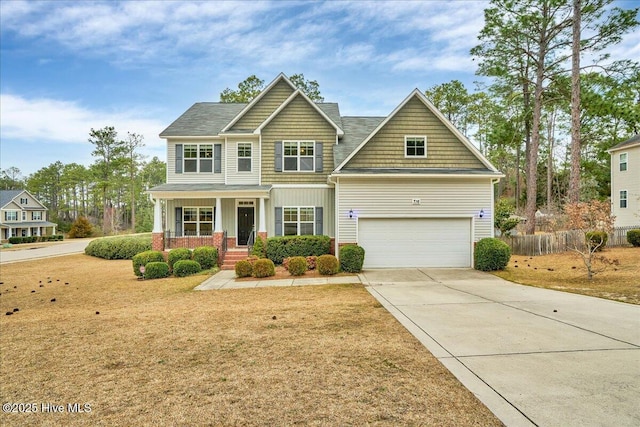 craftsman inspired home featuring fence, a porch, concrete driveway, a garage, and brick siding