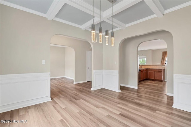 unfurnished dining area featuring light wood-type flooring, beam ceiling, and coffered ceiling