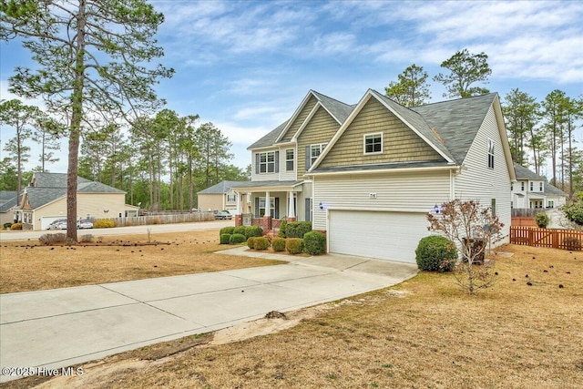 view of front of house with a porch, concrete driveway, and fence