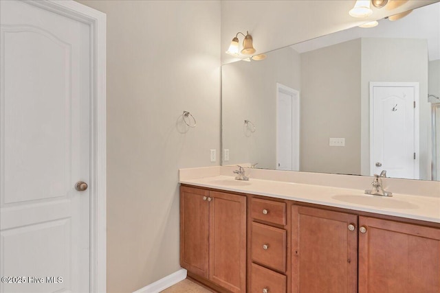 full bathroom featuring a sink, baseboards, and double vanity