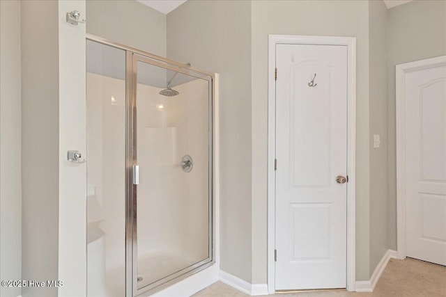 bathroom featuring a shower stall and baseboards