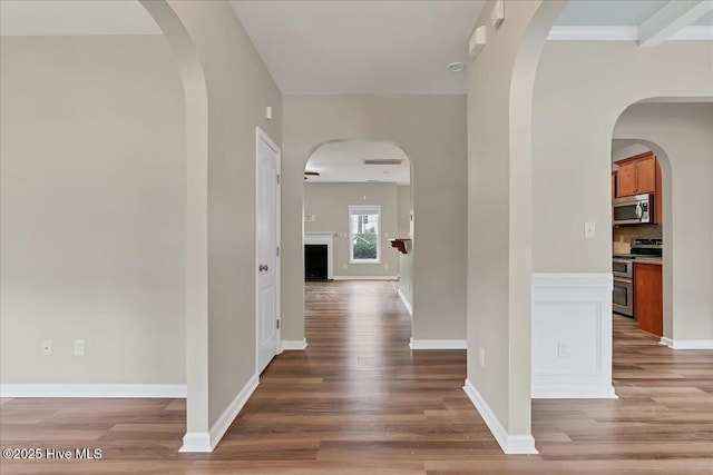 corridor featuring baseboards and wood finished floors