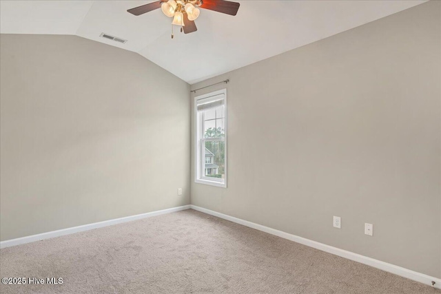 carpeted spare room featuring visible vents, lofted ceiling, baseboards, and ceiling fan