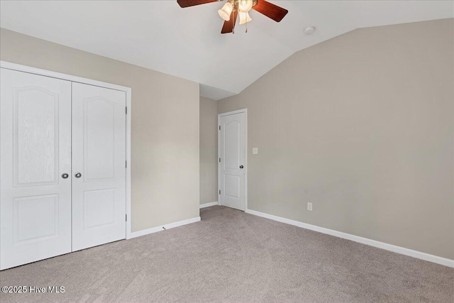 unfurnished bedroom with ceiling fan, baseboards, vaulted ceiling, carpet flooring, and a closet