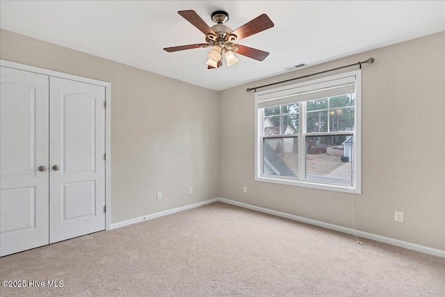 unfurnished bedroom featuring visible vents, a ceiling fan, a closet, carpet floors, and baseboards