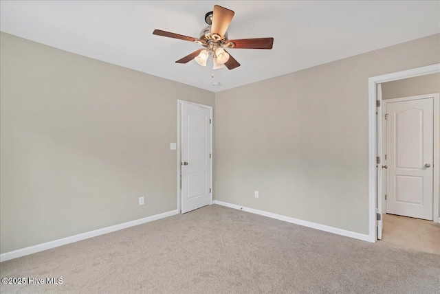 spare room featuring baseboards, light carpet, and ceiling fan