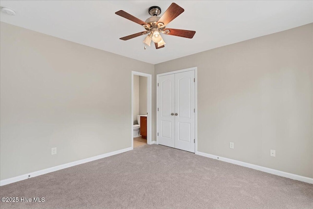 carpeted spare room featuring a ceiling fan and baseboards